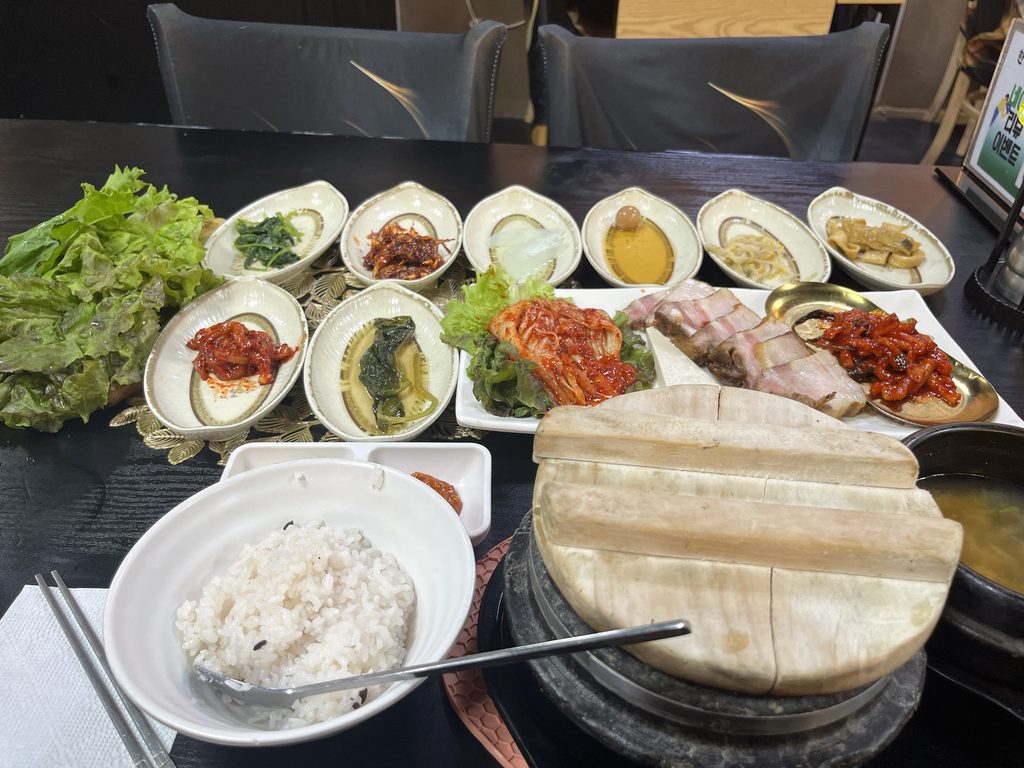 ハンサンチャリムパプサン（한상차림밥상）ポッサム店テーブルいっぱいに並ぶ彩り豊かなおかずは、旅の満足感をぐっと高めてくれる定食でした