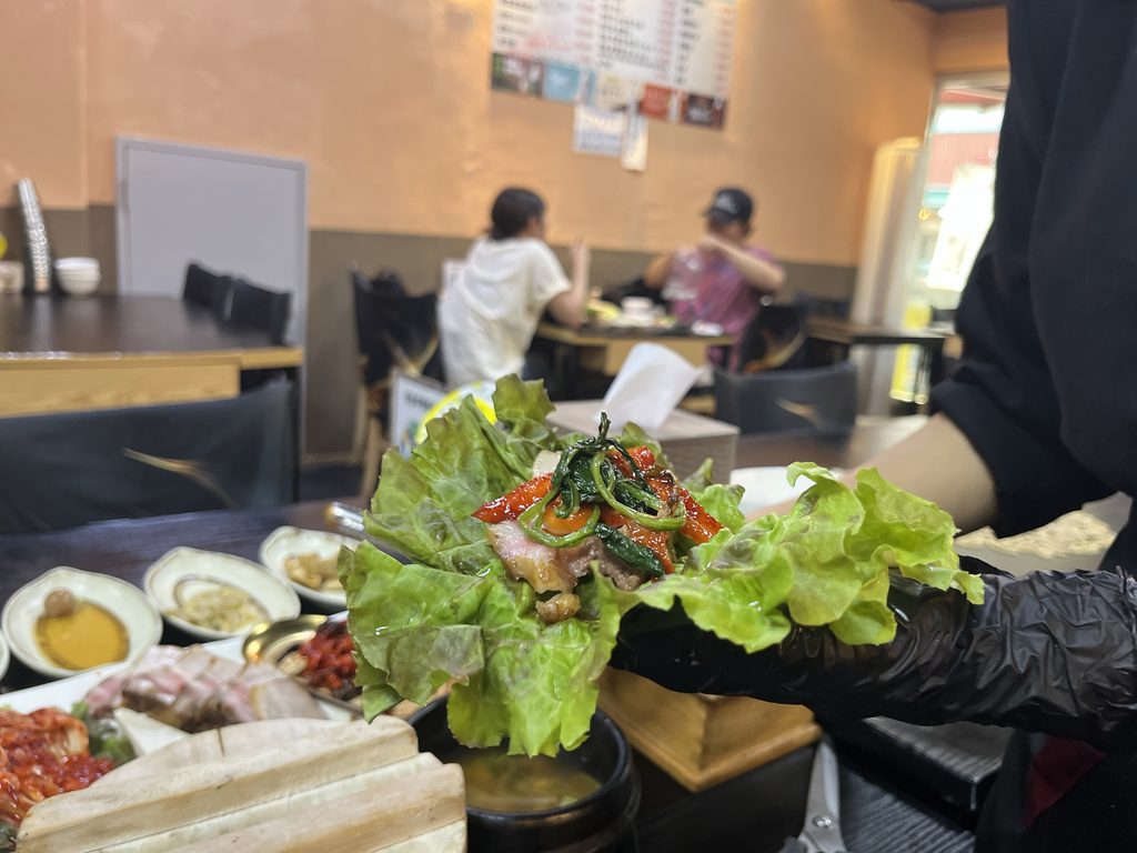 ハンサンチャリムパプサン（한상차림밥상）ポッサム店スタッフさんが美味しそうにサンチュで包んで手渡してくださいました